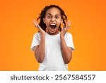 Anger Concept. Portrait of mad African American girl shouting and gesturing. Furious teen screaming loud, tired of school and problems, expressing negative emotions, isolated on yellow studio wall