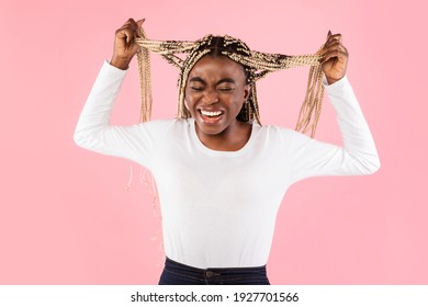 Anger Concept. Portrait of mad black woman shouting, tearing and pulling out her hair. Furious lady screaming loud, tired of her problems, expressing negative emotions, pink studio background