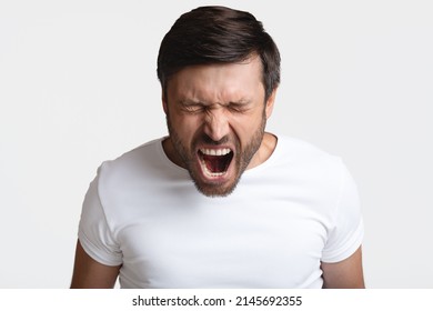 Anger. Mad Male Shouting Loudly In Anger With Eyes Closed Expressing Fury Posing Standing On White Background. Rage, Negative Emotions Concept. Studio Shot - Shutterstock ID 2145692355