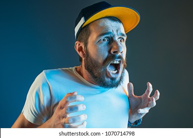 The Anger And Screaming Man. Hate, Rage. Crying Emotional Angry Man In Colorful Bright Lights At Studio Background. Emotional Face. Fan Human Emotions, Facial Expression Concept.