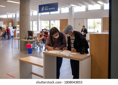 Angers, France - September 3 2020: People Wearing Face Protective Mask. A Consultant Gives Advice To A Pensioner At The Social Security Office At France. Coronavirus Prevention Concept