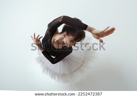 an angle from above on a ballerina up to the waist with her hands showing a dance
