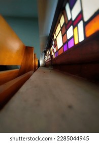 The angle between the colourful window and the chair back