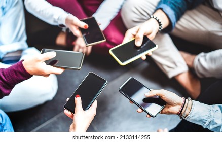 Angle closeup of hands using mobile smart phone - Detail of gen z friends sharing photo on social media network with modern smartphone - Tech life style concept - Selective focus on left lower device - Shutterstock ID 2133114255