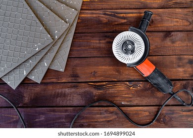 angle grinder and ceramic tile on a wooden background