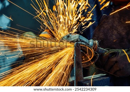 angle grinder, handyman worker using power tools grinding metal in a factory