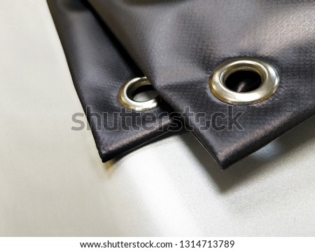 Angle grommets on printed black advertising banner - Image