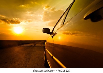 Angle Shot Of A Car Against Sunset In The Background