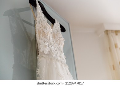 An angle shot of a wedding dress hand on a wardrobe 