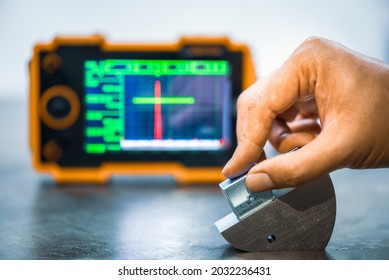 Angle ultrasonic probe or shear wave ultrasonic probe on calibration block in factory. UT calibration. - Shutterstock ID 2032236431