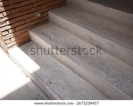 Angle view of a brick wall with concrete stair.