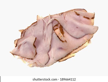 An Angle View Of A Group Of Thin Slices Of Oven Roasted Turkey Breast On A White Background.