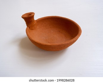 Angle View Of Isolated Miniature Clay Bowl In White Background. Ancient Cookware Using Pottery Technique. Indonesian Javanese Traditional Toys To Educate History Of Human Culture. 