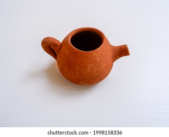 Angle View Of Isolated Miniature Teapot In White Background. Ancient Cookware Using Pottery Technique. Indonesian Javanese Traditional Toys To Educate History Of Human Culture. 