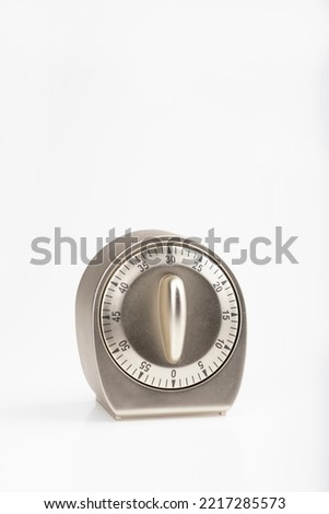 An angle view of a timer with the dial at 30 seconds or 30 minutes on a white background