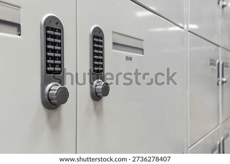 Angled close-up of electronic keypad locking mechanisms on metal storage lockers. Concept of secure access, digital security, privacy, and controlled storage in a workplace or storage facility