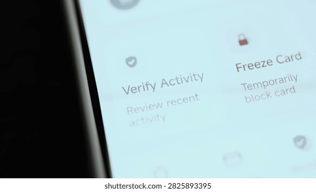 Angled close-up of a mobile banking security screen where verify recent activity before freezing suspicious payment card.