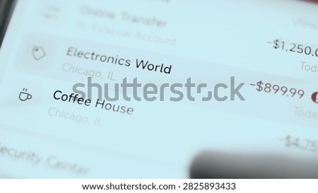 Angled close-up of a mobile banking security screen where recent banking transactions reveal two high value charges.