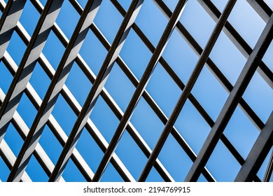 Angled Gray Rafters With Sunlight And Shadows  Under Blue Sky