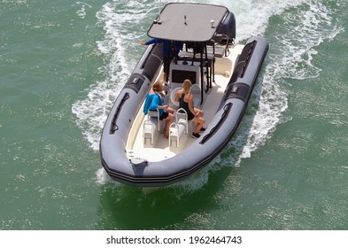 Angled overhead view of an open pontoon motor boat cruising a high speed on Biscayne Bay near Miami Beach,Florida.