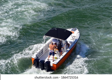 Angled Overhead View Of An Open White And Orange Motor Boat Powered By Three Outboard Engines.