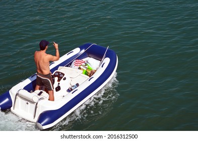 Angled Overhead View Of A Small Sporty Blue And White High-end Pontoon Motor Boat.