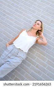 Angled Portrait Of A Stylish Middle Aged Blond Woman In Summer Fashion Taken From A Low Angle Perspective