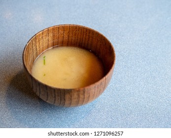 Angled Shot Of A Wooden Sipping Bowl Filled With Miso Soup On A Dining Table