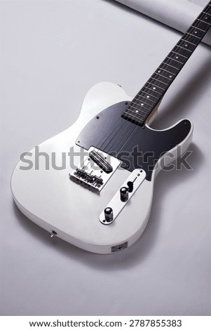 Angled View of a Classic White Solid Body Electric Guitar with Black Pickguard