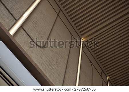 Angled view of decorative wall cladding panels utilizing a custom linen motif paint texture and glowing hidden linear lights.                             