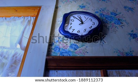 Angled view of melting clock on bathroom wall next to window