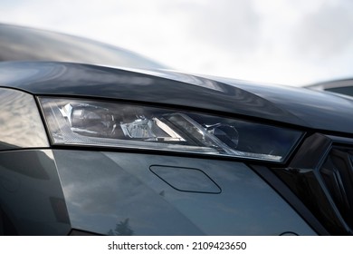 Angled view on headlight of new gray metallic car model  with Matrix Full Led technology, visible washer cover and gloss black grille frame