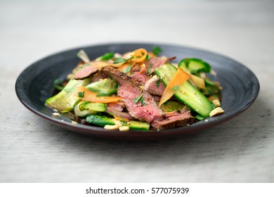 Angled View Of A Plate Of Asian Beef Salad. Inspired By Thai And Vietnamese Cuisine, This Salad Is Made With Fresh Healthy Vegetables (carrots, Onions, Cucumber, Etc) And A Nicely Seared Flank Steak