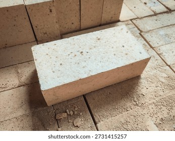 Angled view of refractory firebrick on industrial platform. Heat resistant construction material for furnaces, kilns, and hot industrial processes.