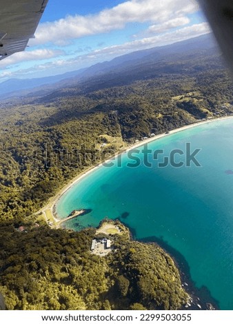 Angled view from a small plane window over the coastline of Stewart Island, New Zealand.