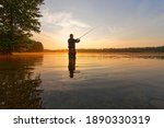 angler catching the fish during summer sunrise