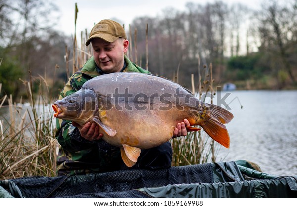 Angler holds big\
carp in his hands.Carp\
Fishing