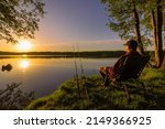 Angler sitting on fishing chair during sunrise