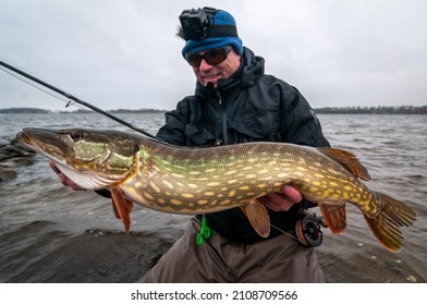 Angler with winter pike caught on fly rod