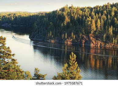 Anglers In Launch Near Island With Granite Rocks And Woods In North Europe, Baltic Sea, Gulf Of Finland. Clean Nordic Nature And Wave Reflections