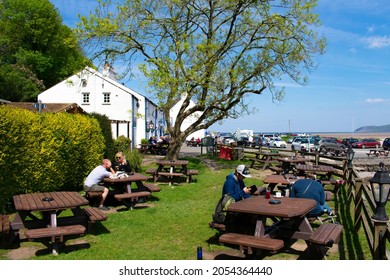 Anglesey - Wales - May 5 2016 : The Old, Charming Ship Inn At Red Wharf Bay View Of The Relaxed Beer Garden With Holiday Makers Sat In The Sun Landscape Aspect Shot