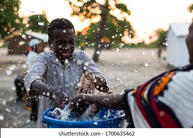 Angoche District, Nampula/ Mozambique - 11.20.2015: Young children play with water from a recently installed water well in a poor village in Northeast Mozambique. 
