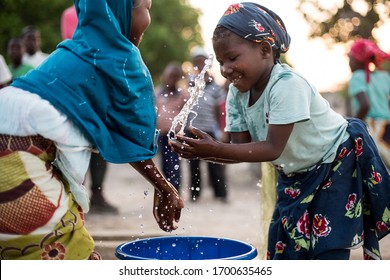 Angoche District, Nampula/ Mozambique - 11.20.2015: Young children play with water from a recently installed water well in a poor village in Northeast Mozambique. 