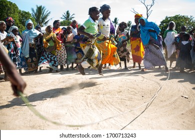 Angoche District, Nampula/ Mozambique - 11.22.2015: Women play jump rope in colourful African cloth as parrot a celebration for an opening of a well in a remote and poor part of northeast Mozambique. 