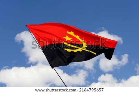 Angola flag isolated on the blue sky with clipping path. close up waving flag of Angola. flag frame with empty space for your text.