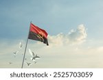 Angola flag waving with flying doves in beautiful sky. Angola flag for Republic Day and Independence Day.