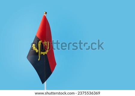 Angolan flag on a blue background, copy space, independence national day of Angola, country freedom, patriotism