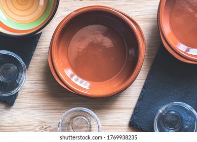 Angri, Italy. Empty Ceramic And Glass Bowls And Plates On A Wooden Cutting Board And Slate Plates Taken From Above. Overhead Shot. Props For Food Photography.