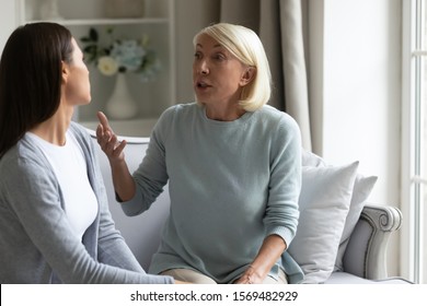 Angry 50s Mother Having Dispute With Grown Up Daughter Different Age Women Sitting On Couch Talking In Loud Voices Having Problems In Relations, Concept Of Spoiled Relationships And Generational Gap