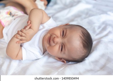 Angry 6 Months Old Baby In Bed. Little Baby Boy Feeling Uncomfortable And Unhappy. Free Space